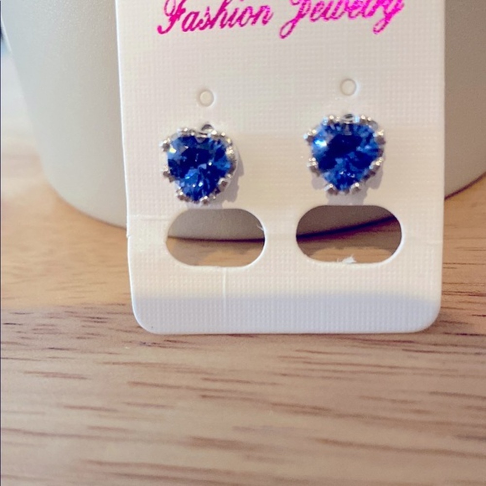 Sterling silver petite heart shaped blue stone earrings.